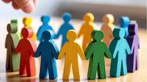 Colorful wooden figures standing together in a diverse and connected group.