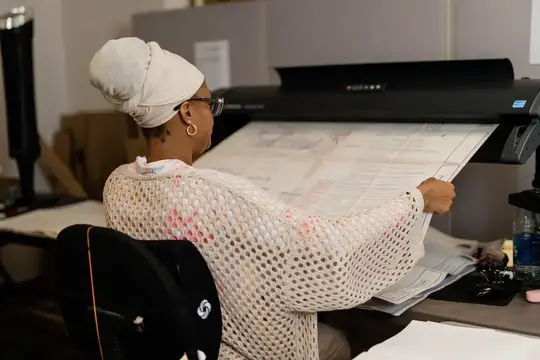 Intellinetics team member is scanning a large-format engineering drawing using a wide-format document scanner.