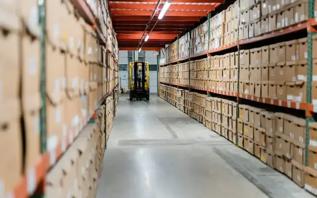 Rows of labeled document storage boxes organized on shelving in a secure records storage facility.