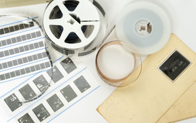 Microfilm reels and microfiche sheets displayed on a flat surface for document archiving.
