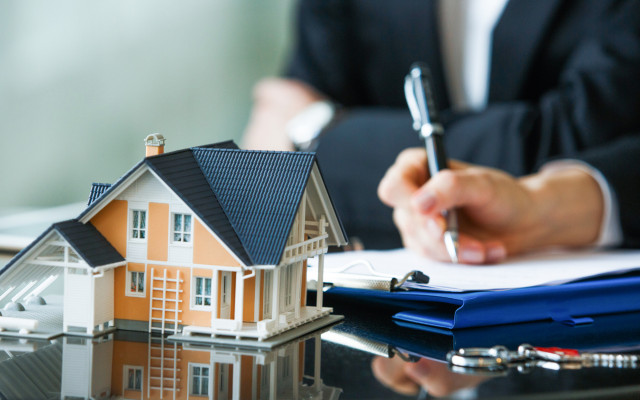 image of a hand signing a contract with a home builder