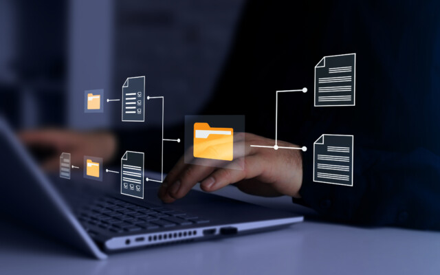Digital document and folder icons overlaid on a laptop keyboard representing document management.