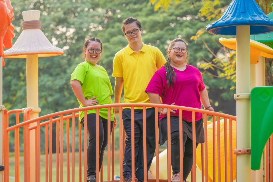 Three Kids with disabilities on a brighly colored bridge
