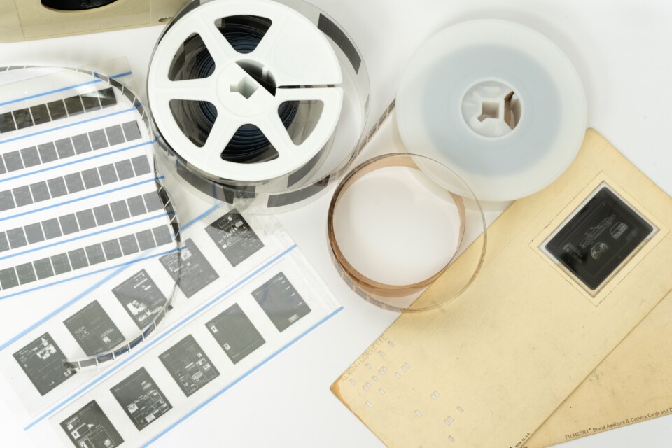 Microfilm reels and microfiche sheets displayed on a flat surface for document archiving.