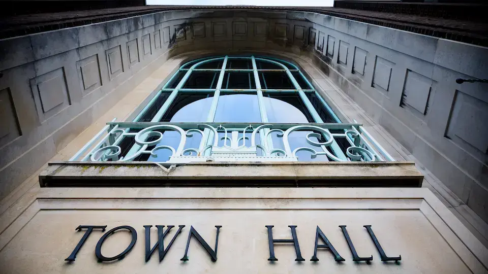 Low-angle view of a historic municipal town hall building with decorative architectural details.