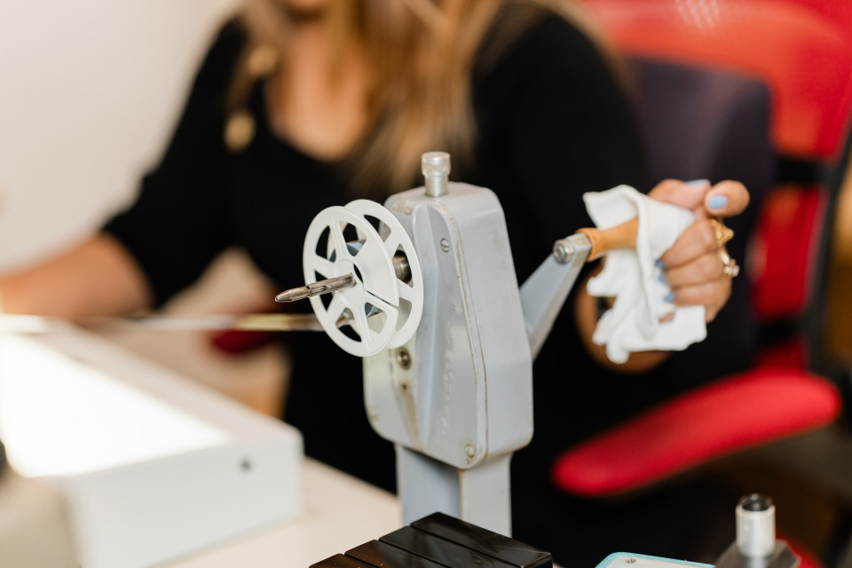 A lady turning film on a microfilm reel