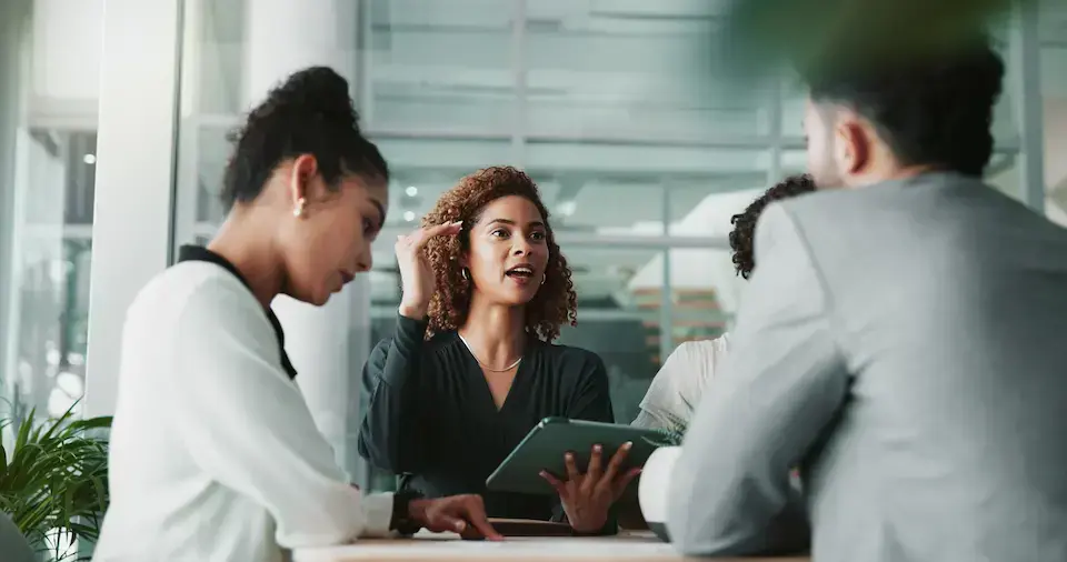 Business professionals collaborating around a table during an office meeting.